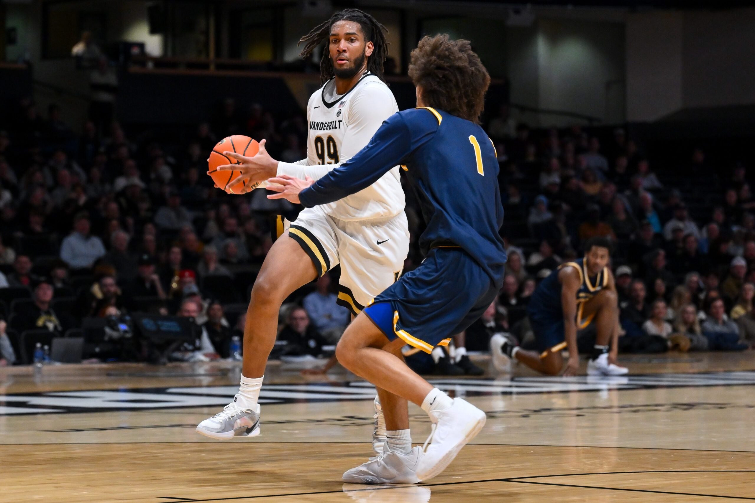 Dec 29, 2025; Nashville, Tennessee, USA;  Vanderbilt Commodores forward Devin McGlockton (99) drives to the basket past New Haven Chargers guard Jabri Fitzpatrick (1) during the second half at Memorial Gymnasium. Mandatory Credit: Steve Roberts-Imagn Images