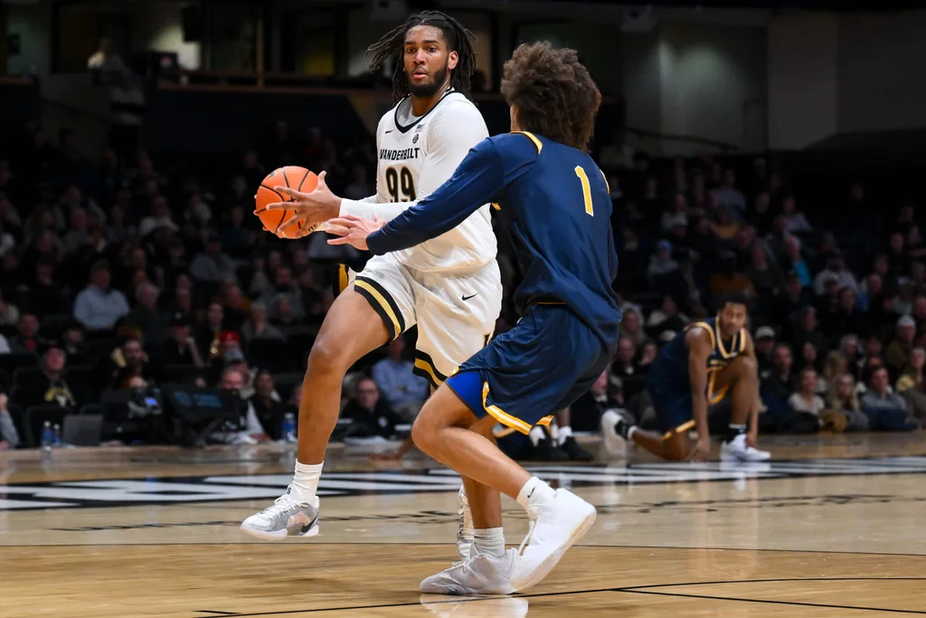 Dec 29, 2025; Nashville, Tennessee, USA; Vanderbilt Commodores forward Devin McGlockton (99) drives to the basket past New Haven Chargers guard Jabri Fitzpatrick (1) during the second half at Memorial Gymnasium. Mandatory Credit: Steve Roberts-Imagn Images