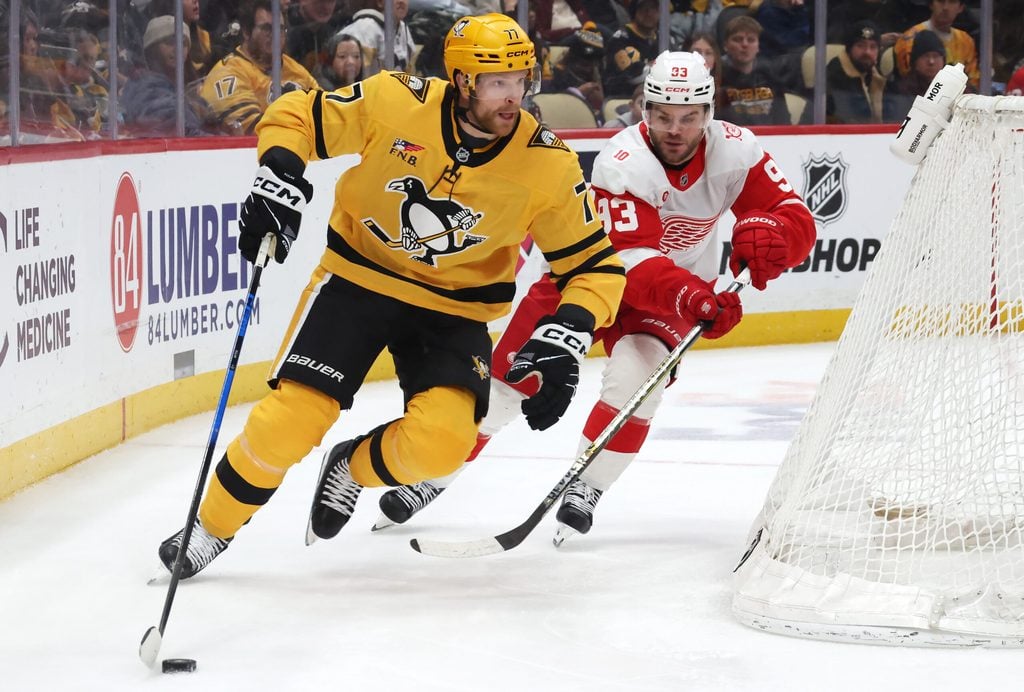 Jan 1, 2026; Pittsburgh, Pennsylvania, USA; Pittsburgh Penguins defenseman Brett Kulak (77) moves the puck as Detroit Red Wings right wing Alex Debrincat (93) chases during the third period at PPG Paints Arena. Mandatory Credit: Charles LeClaire-Imagn Images