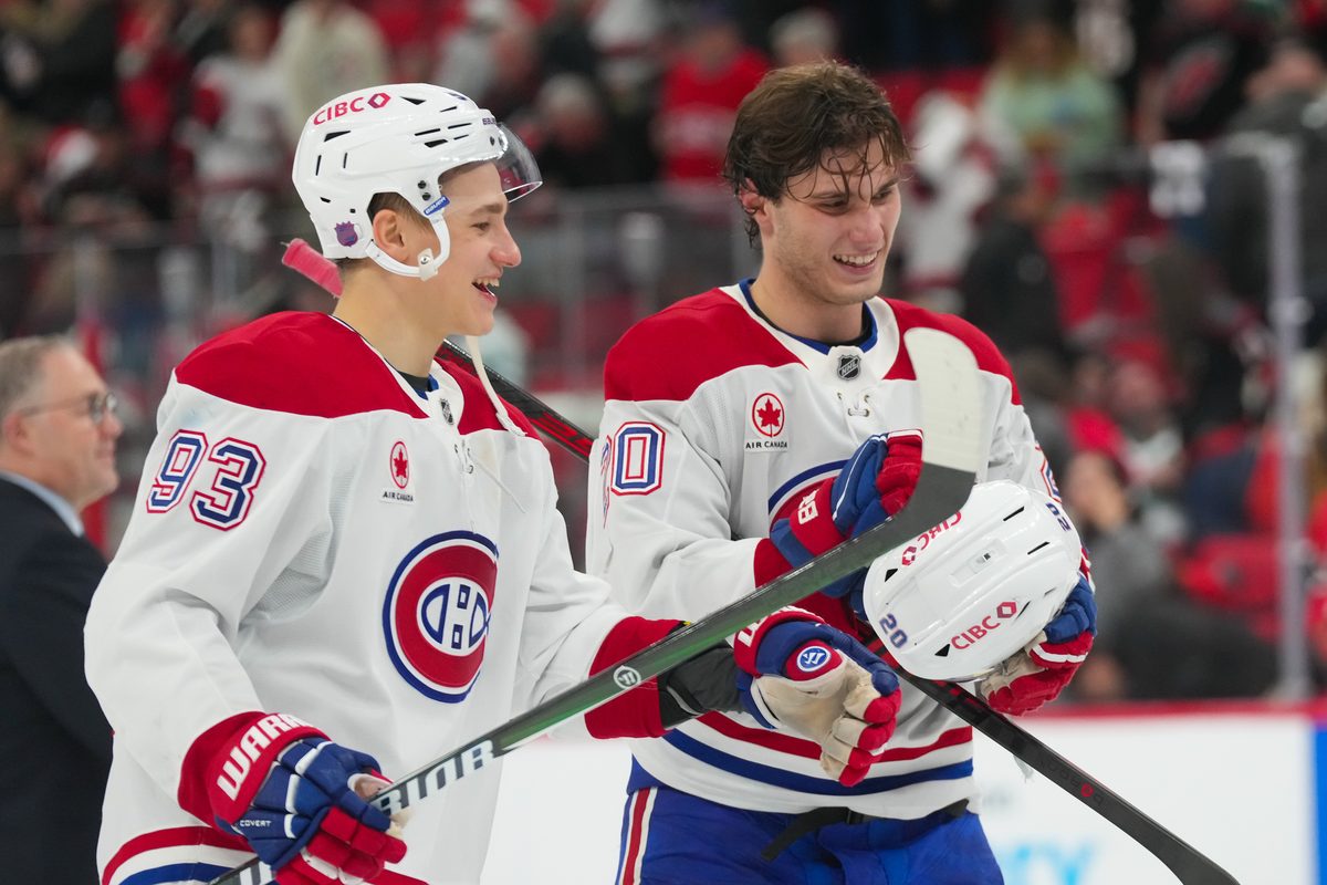 Jan 1, 2026; Raleigh, North Carolina, USA; MontrÈal Canadiens left wing Juraj Slafkovsky (20) and right wing Ivan Demidov (93) celebrate their victory against the Carolina Hurricanes at Lenovo Center. Mandatory Credit: James Guillory-Imagn Images