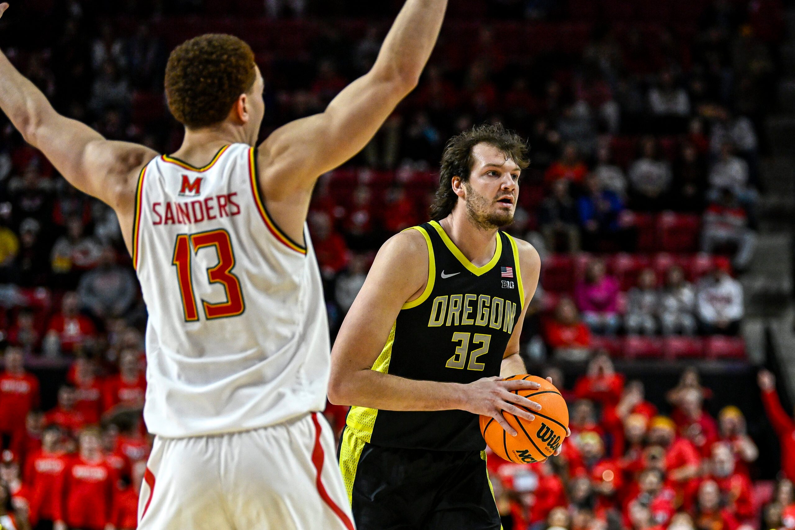 Jan 2, 2026; College Park, Maryland, USA;  Oregon Ducks center Nate Bittle (32) looks to pass as Maryland Terrapins forward Elijah Saunders (13) defends during the first half at Xfinity Center. Mandatory Credit: Tommy Gilligan-Imagn Images