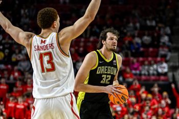 Jan 2, 2026; College Park, Maryland, USA;  Oregon Ducks center Nate Bittle (32) looks to pass as Maryland Terrapins forward Elijah Saunders (13) defends during the first half at Xfinity Center. Mandatory Credit: Tommy Gilligan-Imagn Images