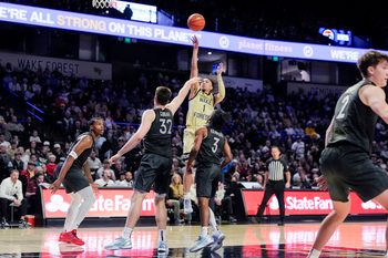 Jan 3, 2026; Winston-Salem, North Carolina, USA; Wake Forest Demon Deacons guard Nate Calmese (1) shoots the ball over Virginia Tech Hokies center Christian Gurdak (32) and guard Ben Hammond (3) during the first half at Lawrence Joel Veterans Memorial Coliseum. Mandatory Credit: Jim Dedmon-Imagn Images