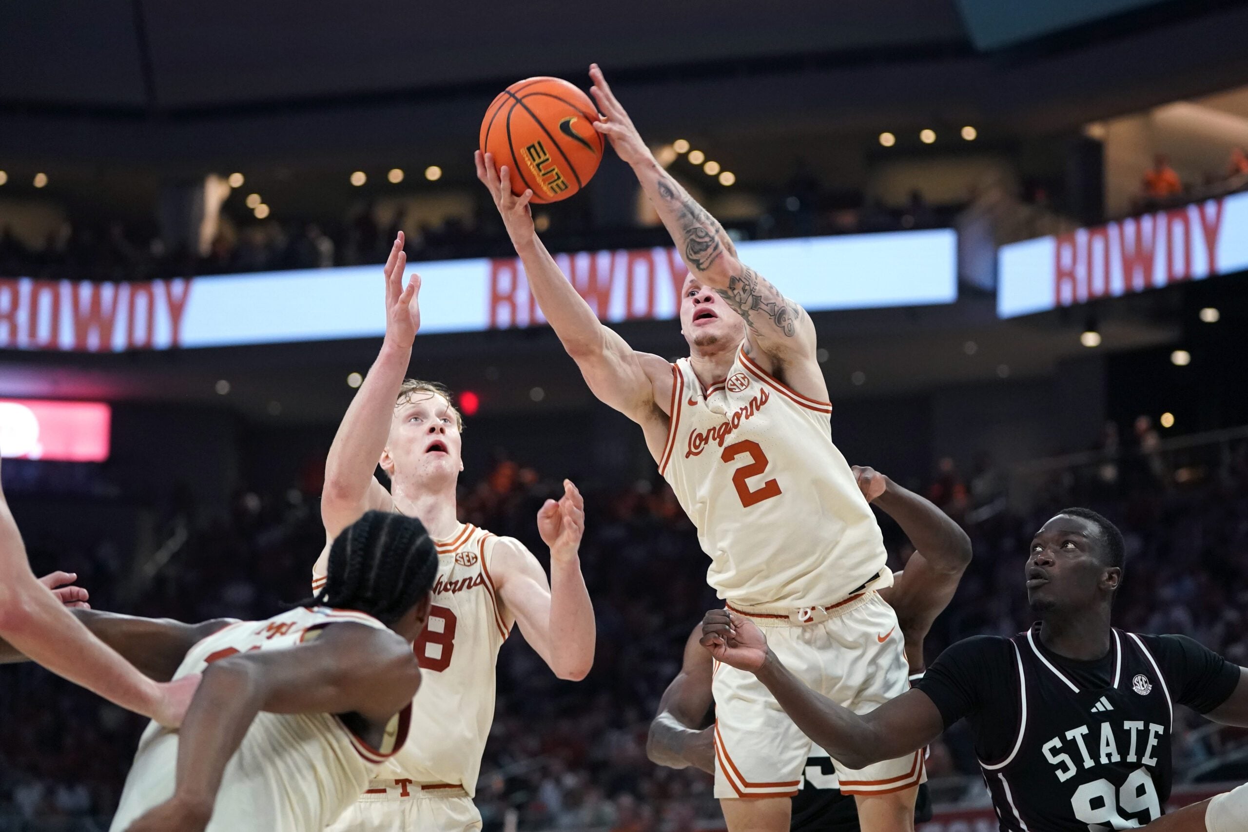 Jan 3, 2026; Austin, Texas, USA; Texas Longhorns guard Chendall Weaver (2) rebounds against Mississippi State Bulldogs forward Achor Achor (99) during the second half at Moody Center. Mandatory Credit: Dustin Safranek-Imagn Images