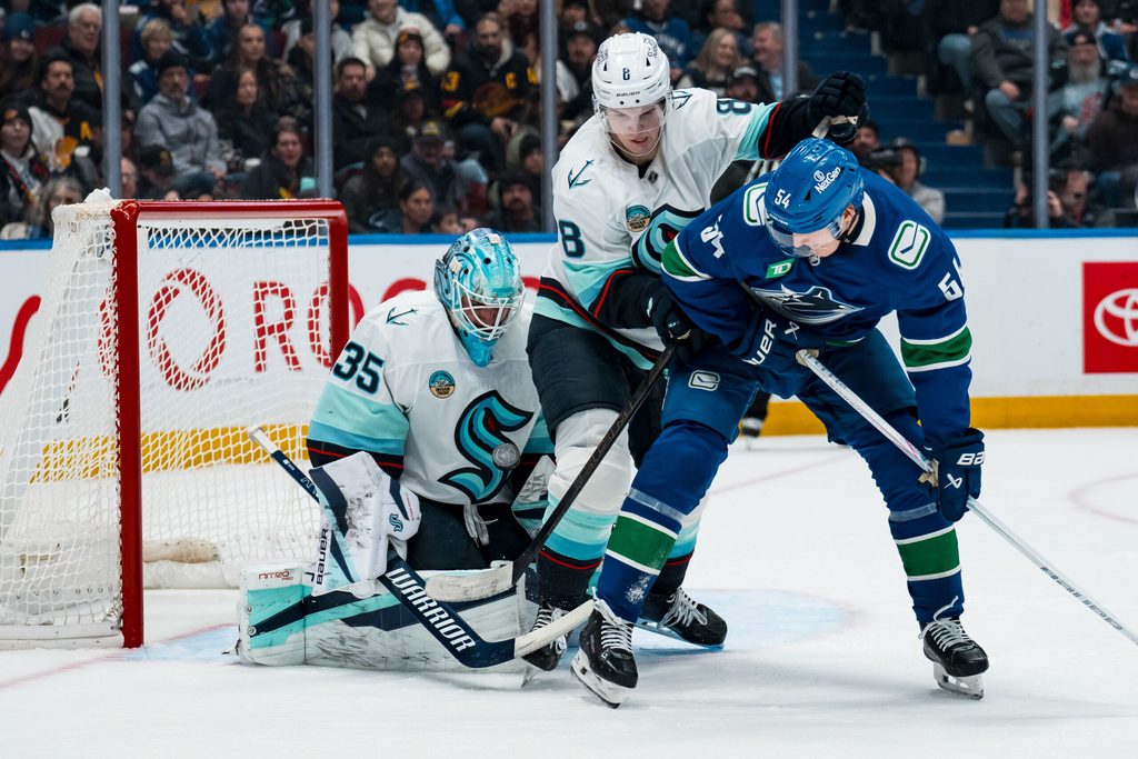 Jan 2, 2026; Vancouver, British Columbia, CAN; Seattle Kraken defenseman Cale Fleury (8) and Vancouver Canucks forward Aatu Raty (54) battle as goalie Joey Daccord (35) makes a save in the second period at Rogers Arena. Mandatory Credit: Bob Frid-Imagn Images