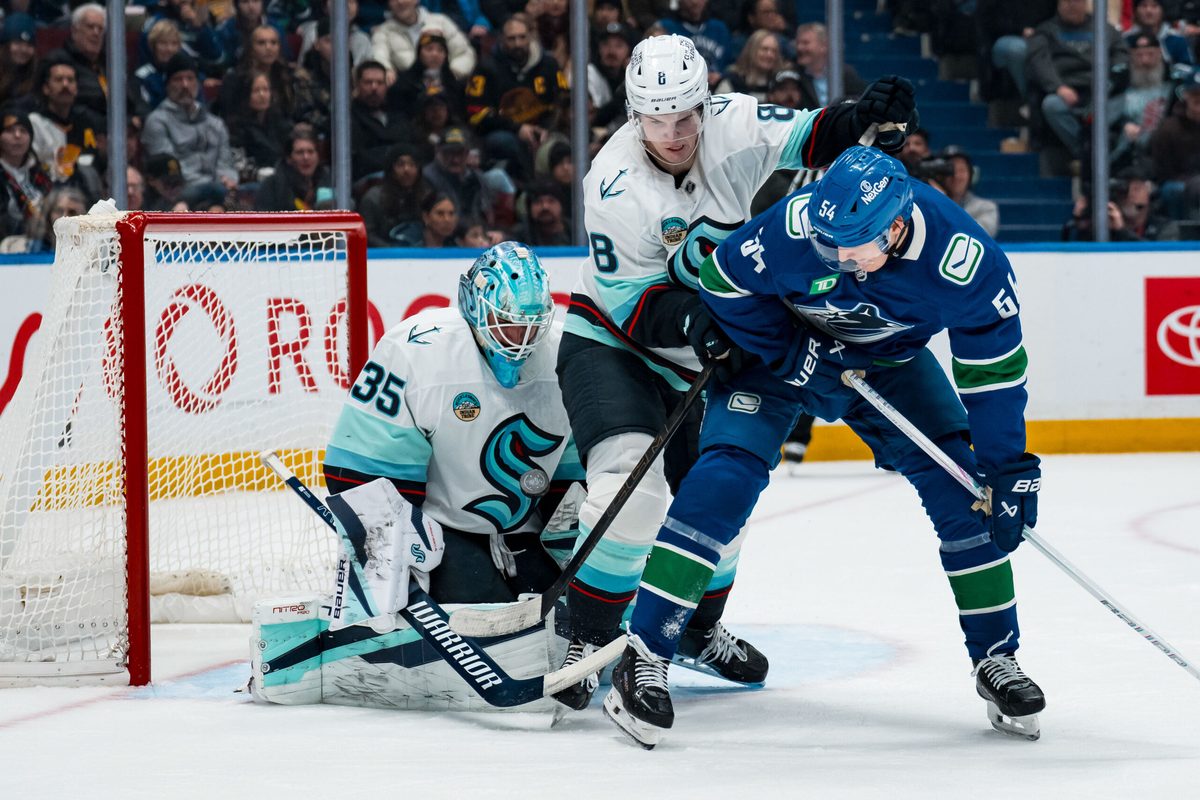 Jan 2, 2026; Vancouver, British Columbia, CAN; Seattle Kraken defenseman Cale Fleury (8) and Vancouver Canucks forward Aatu Raty (54) battle as goalie Joey Daccord (35) makes a save in the second period at Rogers Arena. Mandatory Credit: Bob Frid-Imagn Images