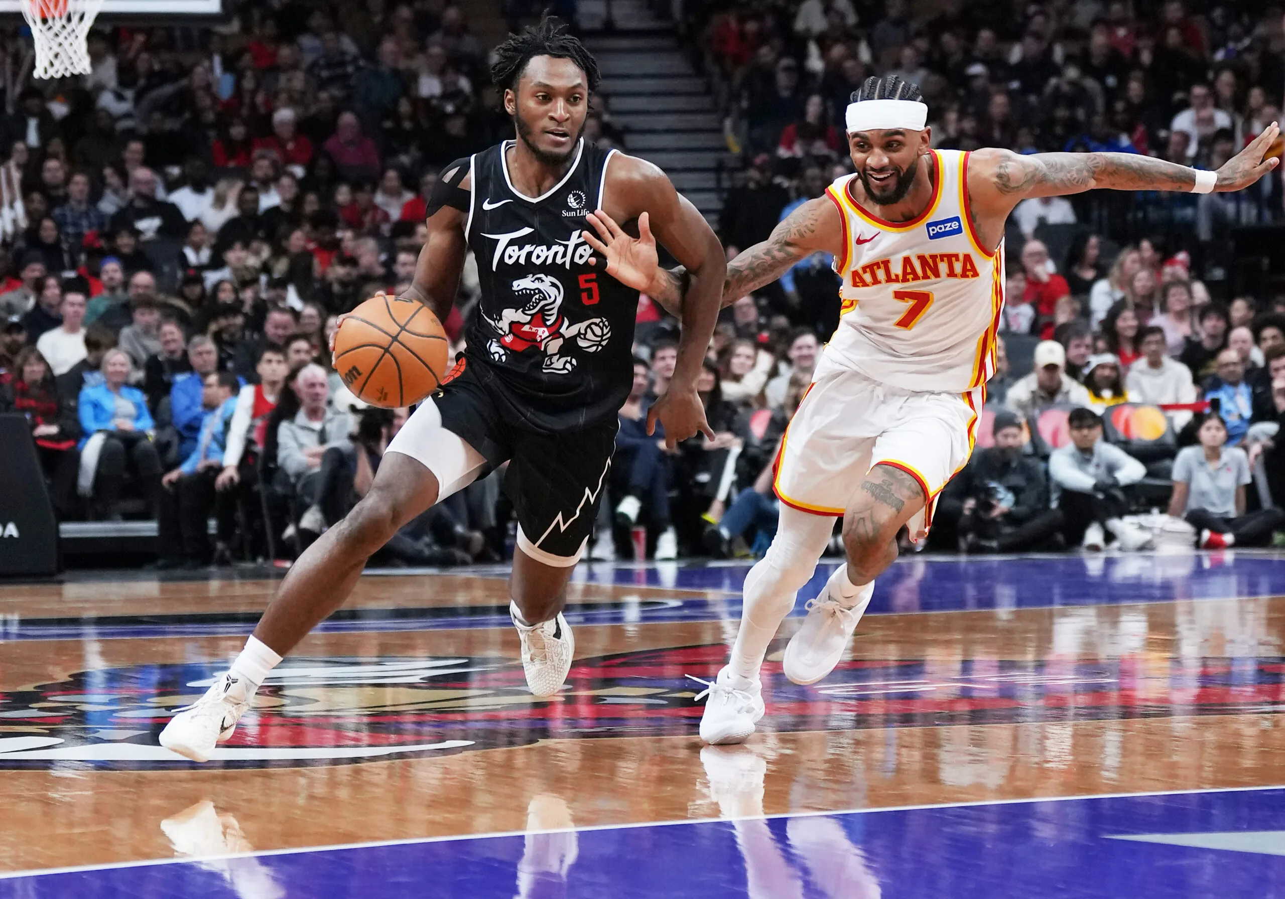 Jan 3, 2026; Toronto, Ontario, CAN; Toronto Raptors guard Immanuel Quickley (5) controls the ball as Atlanta Hawks guard Nickeil Alexander-Walker (7) tries to defend during the fourth quarter at Scotiabank Arena. Mandatory Credit: Nick Turchiaro-Imagn Images