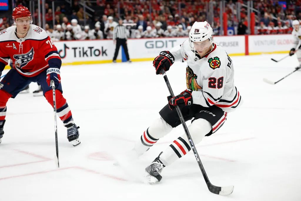 Jan 3, 2026; Washington, District of Columbia, USA; Chicago Blackhawks left wing Andre Burakovsky (28) skates with the puck as Washington Capitals defenseman John Carlson (74) defends during the third period at Capital One Arena. Mandatory Credit: Geoff Burke-Imagn Images