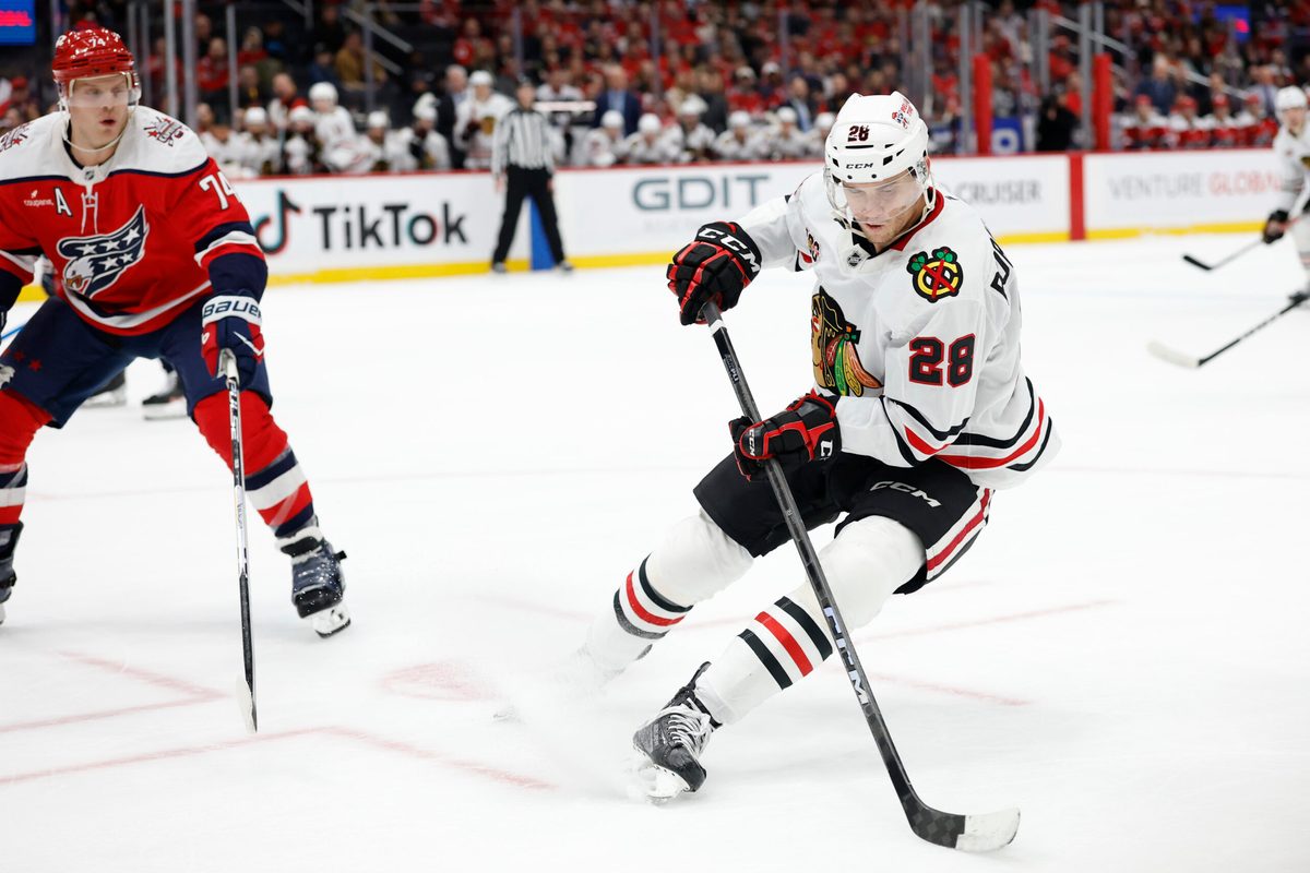 Jan 3, 2026; Washington, District of Columbia, USA; Chicago Blackhawks left wing Andre Burakovsky (28) skates with the puck as Washington Capitals defenseman John Carlson (74) defends during the third period at Capital One Arena. Mandatory Credit: Geoff Burke-Imagn Images