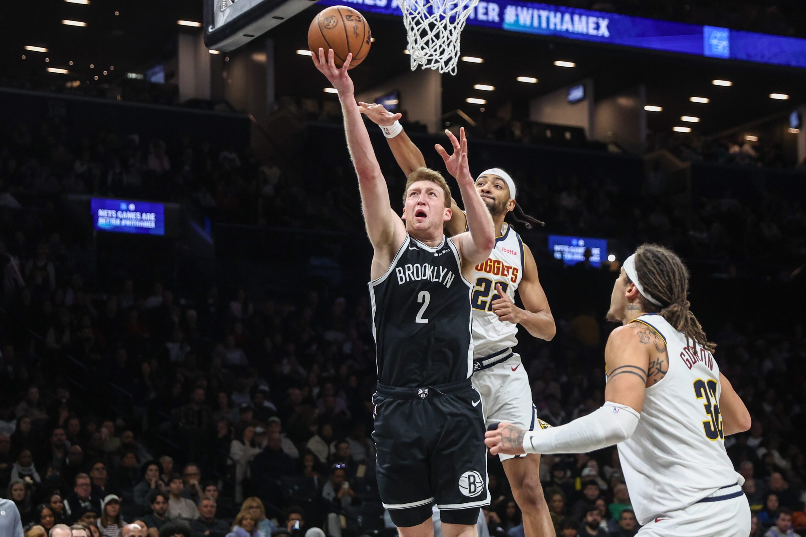Jan 4, 2026; Brooklyn, New York, USA;  Brooklyn Nets forward Danny Wolf (2) drives past Denver Nuggets forward Zeke Nnaji (22) in the fourth quarter at Barclays Center. Mandatory Credit: Wendell Cruz-Imagn Images