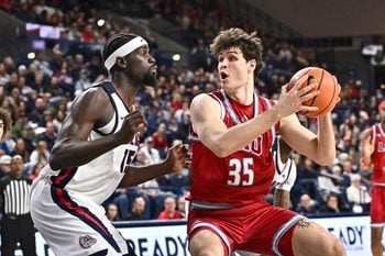 Jan 4, 2026; Spokane, Washington, USA; Loyola Marymount Lions forward Rokas Jocius (35) shoots the ball against Gonzaga Bulldogs forward Graham Ike (15) in the first half at McCarthey Athletic Center. Mandatory Credit: James Snook-Imagn Images