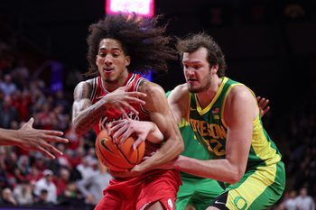 Jan 5, 2026; Piscataway, New Jersey, USA; Rutgers Scarlet Knights guard Lino Mark (2) rebounds against Oregon Ducks center Nate Bittle (32) during the second half at Jersey Mike's Arena. Mark was called for a foul on the play. Mandatory Credit: Vincent Carchietta-Imagn Images