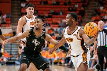 Jan 6, 2026; Stillwater, Oklahoma, USA; Oklahoma State Cowboys guard Kanye Clary (1) passes the ball around UCF Knights guard Themus Fulks (1) during the first half at Gallagher-Iba Arena. Mandatory Credit: William Purnell-Imagn Images