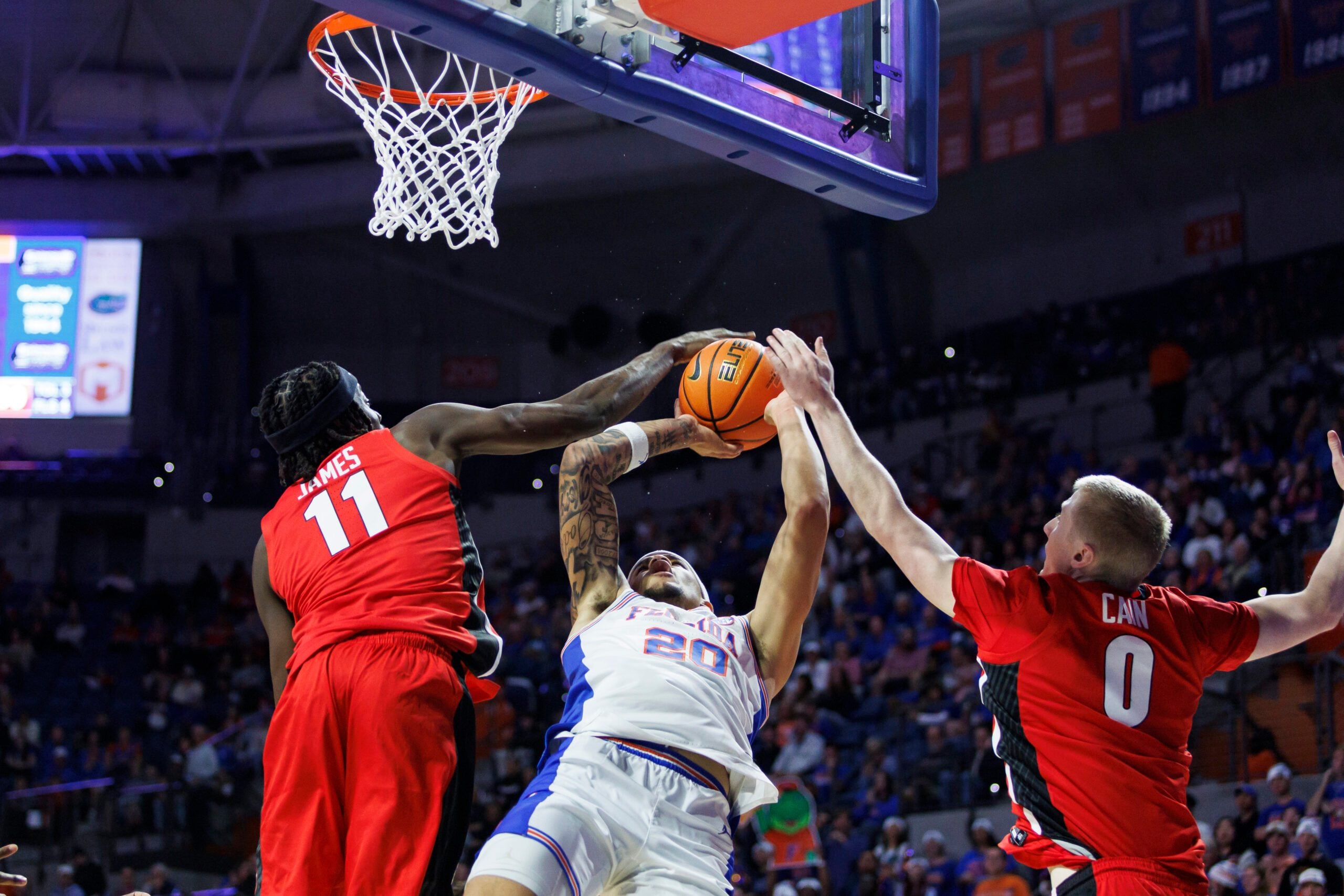 Jan 6, 2026; Gainesville, Florida, USA; Florida Gators guard Isaiah Brown (20) is fouled by Georgia Bulldogs forward Dylan James (11) during the second half at Exactech Arena at the Stephen C. O'Connell Center. Mandatory Credit: Morgan Tencza-Imagn Images