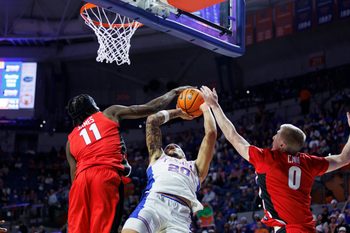 Jan 6, 2026; Gainesville, Florida, USA; Florida Gators guard Isaiah Brown (20) is fouled by Georgia Bulldogs forward Dylan James (11) during the second half at Exactech Arena at the Stephen C. O'Connell Center. Mandatory Credit: Morgan Tencza-Imagn Images