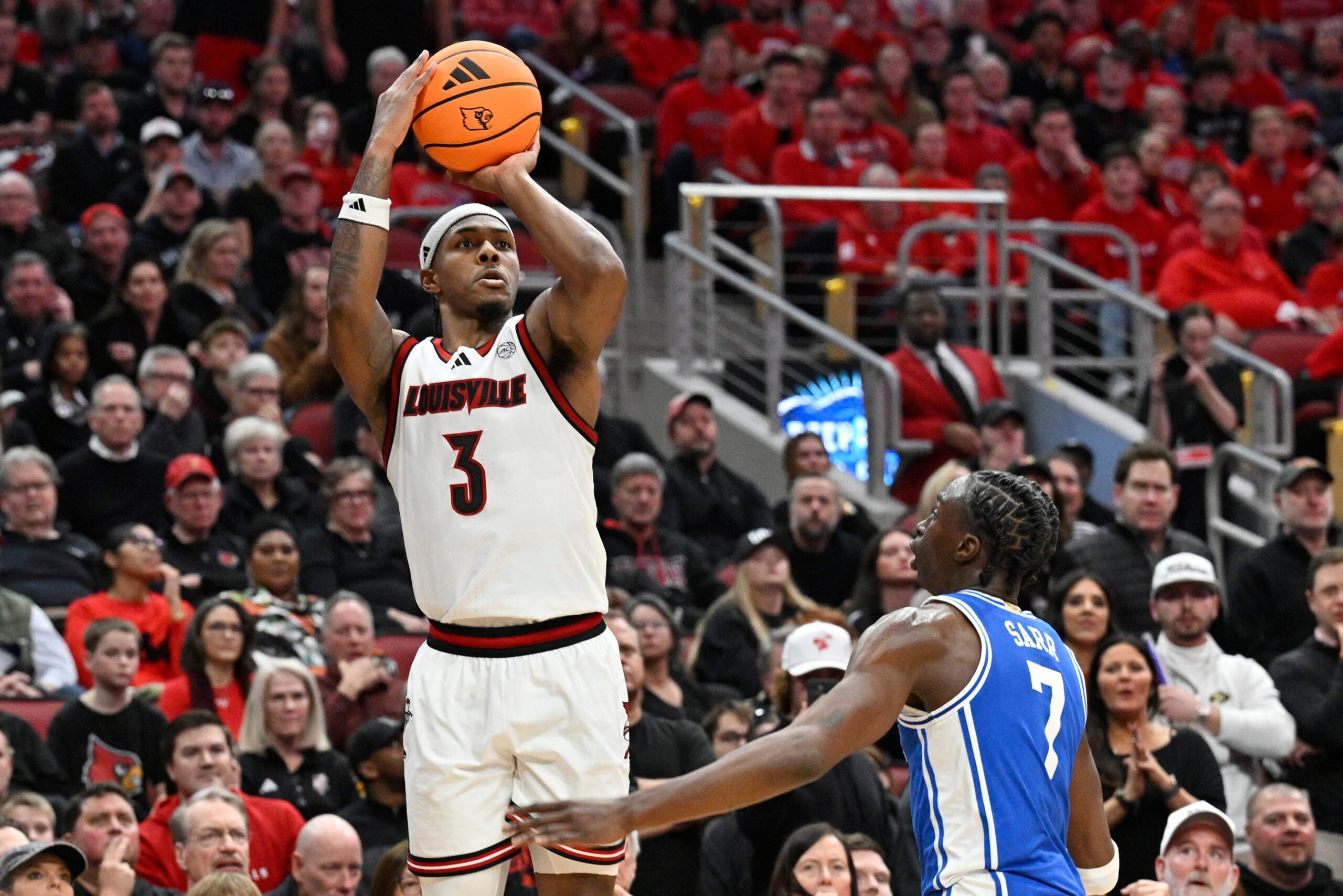 Jan 6, 2026; Louisville, Kentucky, USA;  Louisville Cardinals guard Ryan Conwell (3) shoots against Duke Blue Devils guard Dame Sarr (7) during the second half at KFC Yum! Center. Duke defeated Louisville 84-73. Mandatory Credit: Jamie Rhodes-Imagn Images