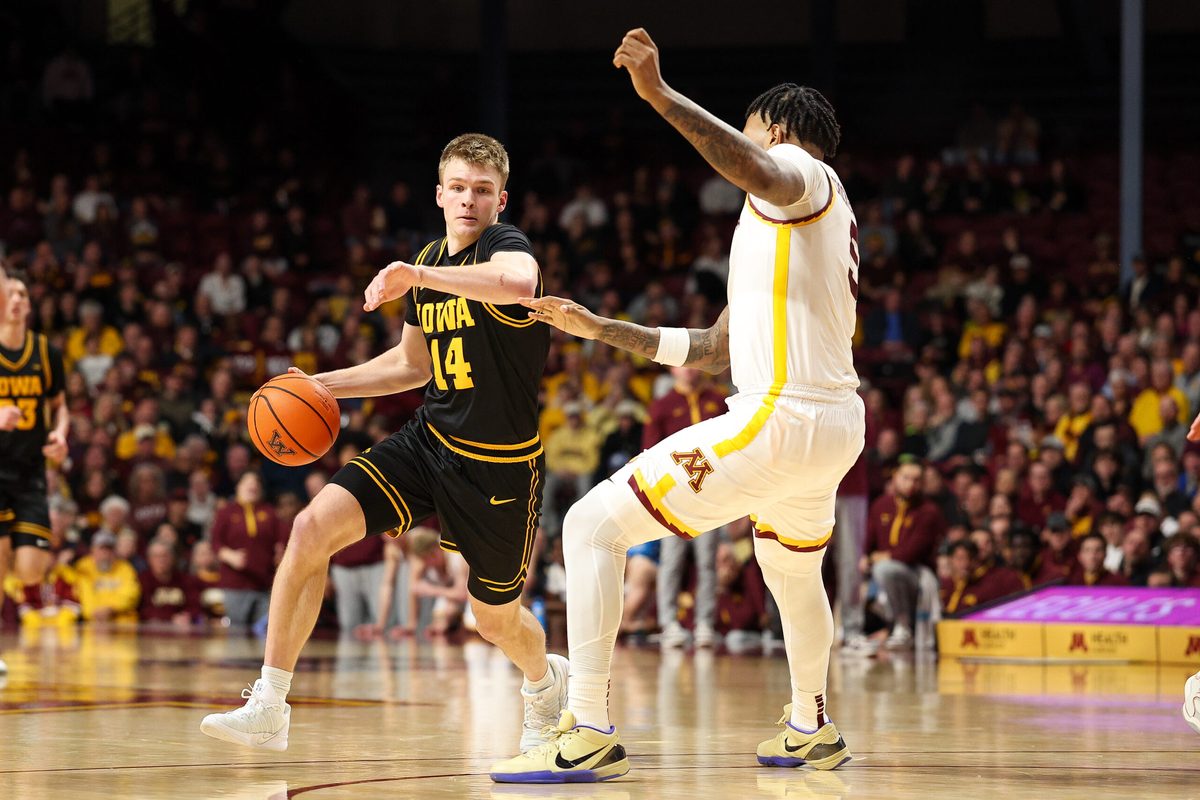 Jan 6, 2026; Minneapolis, Minnesota, USA; Iowa Hawkeyes guard Bennett Stirtz (14) works around Minnesota Golden Gophers forward Jaylen Crocker-Johnson (5) during the second half at Williams Arena. Mandatory Credit: Matt Krohn-Imagn Images