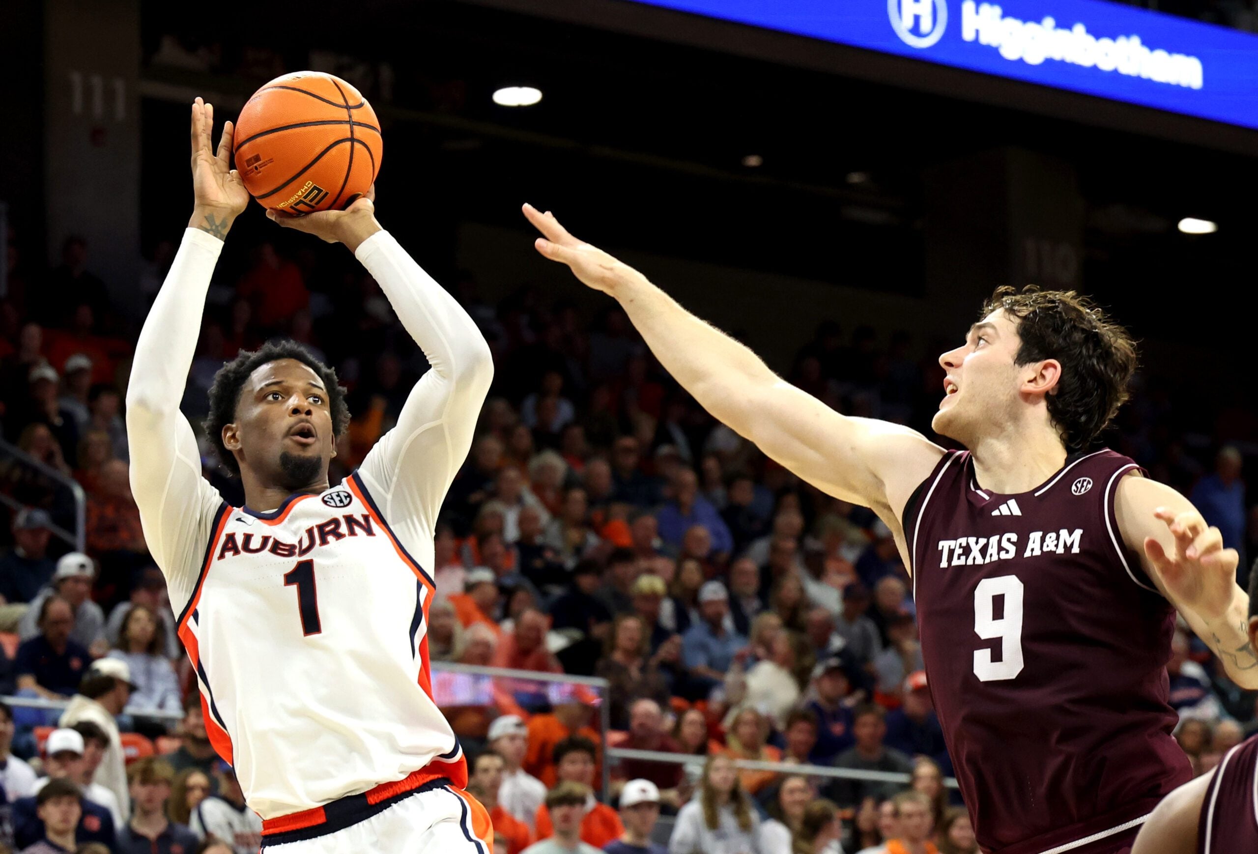 Dec 3, 2025; Auburn, Alabama, USA;  Auburn Tigers guard Kevin Overton (1) takes a shot over Texas A&M Aggies guard Ruben Dominguez (9) during the second half at Neville Arena. Mandatory Credit: John Reed-Imagn Images