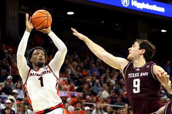 Dec 3, 2025; Auburn, Alabama, USA;  Auburn Tigers guard Kevin Overton (1) takes a shot over Texas A&M Aggies guard Ruben Dominguez (9) during the second half at Neville Arena. Mandatory Credit: John Reed-Imagn Images