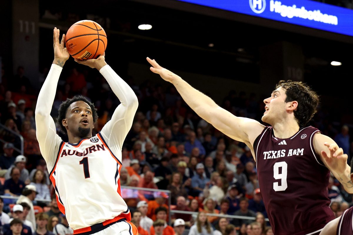 Dec 3, 2025; Auburn, Alabama, USA; Auburn Tigers guard Kevin Overton (1) takes a shot over Texas A&M Aggies guard Ruben Dominguez (9) during the second half at Neville Arena. Mandatory Credit: John Reed-Imagn Images
