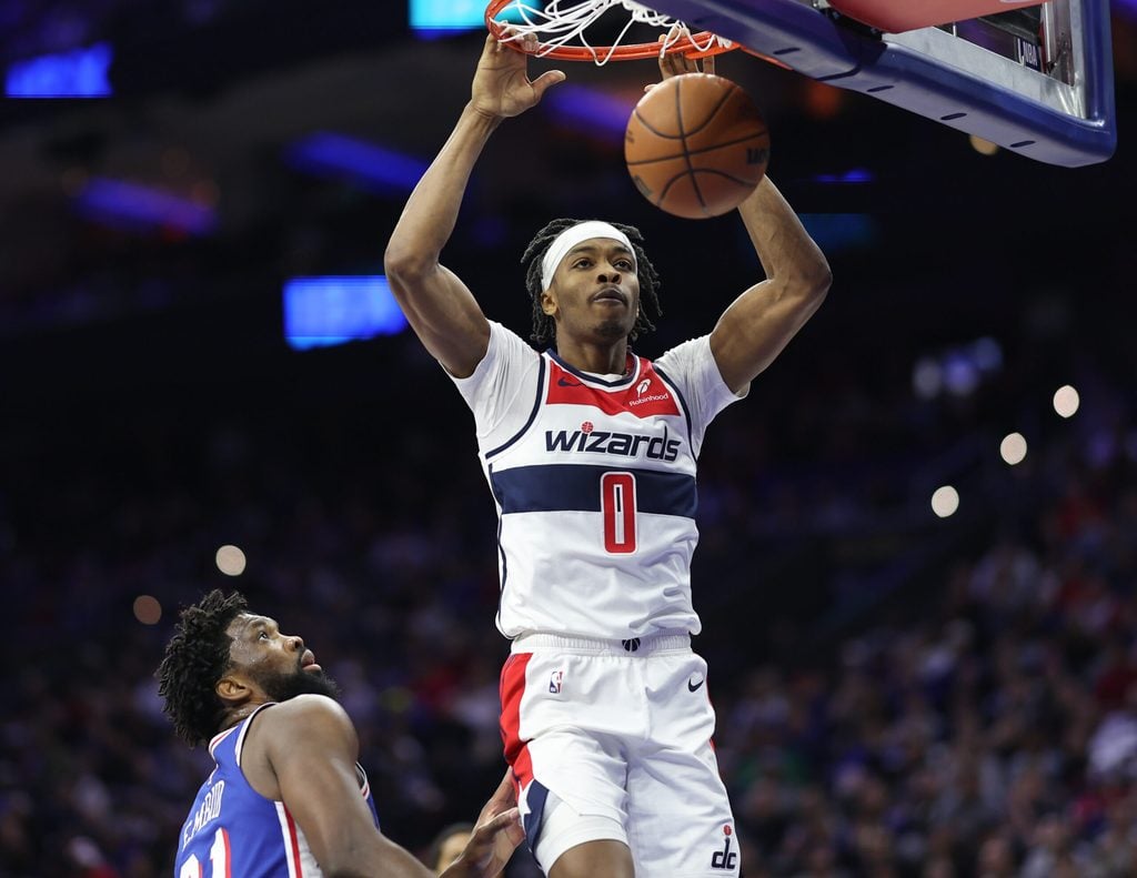 Jan 7, 2026; Philadelphia, Pennsylvania, USA; Washington Wizards guard Bilal Coulibaly (0) dunks the ball in front of Philadelphia 76ers center Joel Embiid (21) during the second quarter at Xfinity Mobile Arena. Mandatory Credit: Bill Streicher-Imagn Images