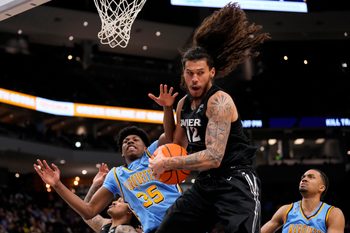 Jan 7, 2026; Milwaukee, Wisconsin, USA;  Xavier Musketeers forward Tre Carroll (12) grabs a rebound in front of Marquette Golden Eagles forward Michael Phillips II (35) during the second half at Fiserv Forum. Mandatory Credit: Jeff Hanisch-Imagn Images