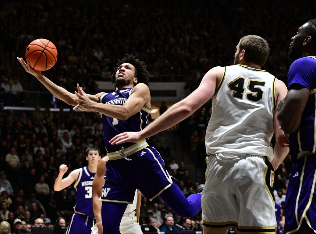 Jan 7, 2026; West Lafayette, Indiana, USA; Washington Huskies guard Desmond Claude (1) shoots the ball in front of Purdue Boilermakers center Oscar Cluff (45) during the first half at Mackey Arena. Mandatory Credit: Marc Lebryk-Imagn Images