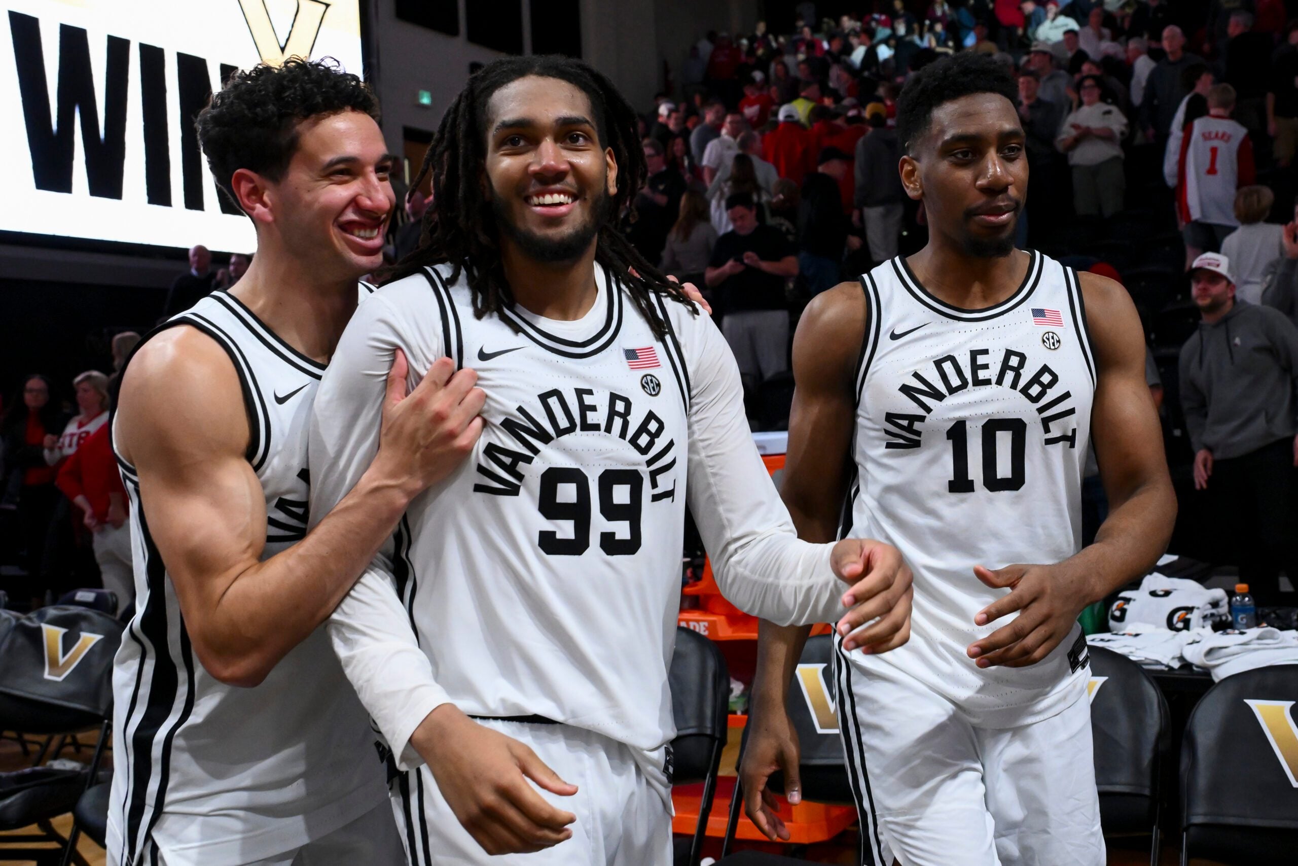Jan 7, 2026; Nashville, Tennessee, USA;  Vanderbilt Commodores guard Miles Keeffe (25), forward Devin McGlockton (99), and forward Ak Okereke (10) celebrate the win against the Alabama Crimson Tide during the second half at Memorial Gymnasium. Mandatory Credit: Steve Roberts-Imagn Images