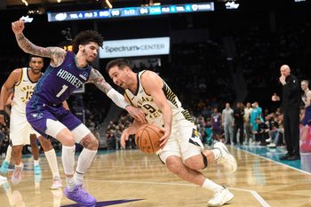 Jan 8, 2026; Charlotte, North Carolina, USA;  Indiana Pacers guard T.J. McConnell (9) drives past Charlotte Hornets guard LaMelo Ball (1) during the second half at the Spectrum Center. Mandatory Credit: Sam Sharpe-Imagn Images