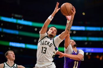 Jan 9, 2026; Los Angeles, California, USA; Milwaukee Bucks guard Ryan Rollins (13) gets the rebound against Los Angeles Lakers center Jaxson Hayes (11) during the second half at Crypto.com Arena. Mandatory Credit: Gary A. Vasquez-Imagn Images