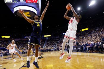 Jan 10, 2026; Ann Arbor, Michigan, USA;  Wisconsin Badgers guard John Blackwell (25) shoots on Michigan Wolverines forward Morez Johnson Jr. (21) in the second half at Crisler Center. Mandatory Credit: Rick Osentoski-Imagn Images