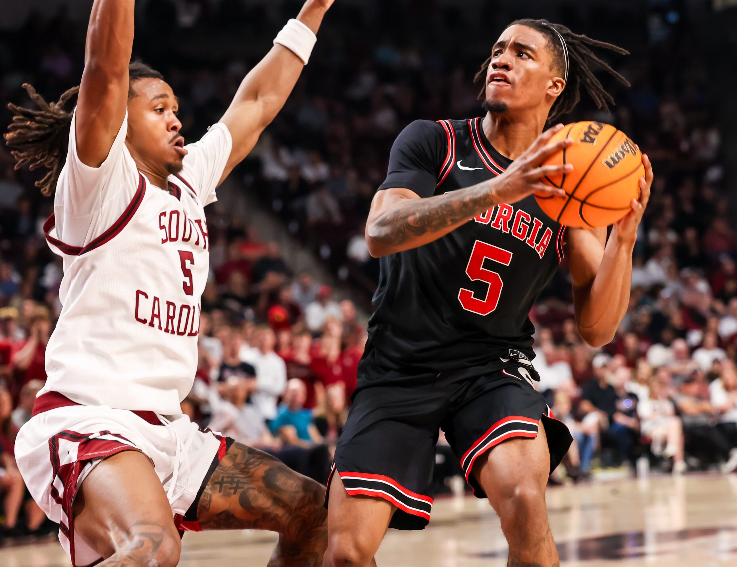 Jan 10, 2026; Columbia, South Carolina, USA; Georgia Bulldogs guard Jeremiah Wilkinson (5) looks to get around South Carolina Gamecocks guard Meechie Johnson (5) in the second half at Colonial Life Arena. Mandatory Credit: Jeff Blake-Imagn Images