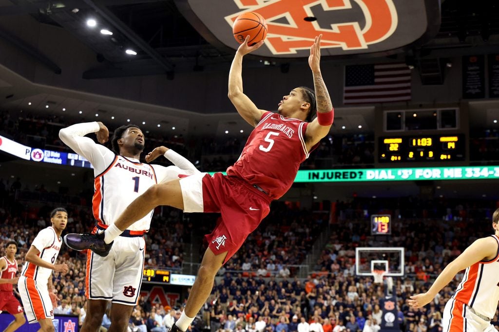 Jan 10, 2026; Auburn, Alabama, USA; Arkansas Razorbacks guard Darius Acuff Jr. (5) gets a shot off after being fouled by Auburn Tigers guard Kevin Overton (1) during the first half at Neville Arena. Mandatory Credit: John Reed-Imagn Images