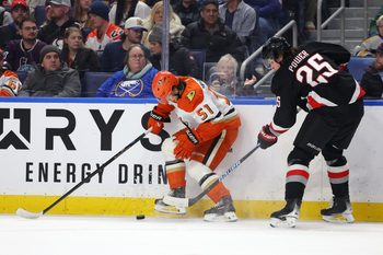 Jan 10, 2026; Buffalo, New York, USA;  Anaheim Ducks defenseman Olen Zellweger (51) tries to control the puck as Buffalo Sabres defenseman Owen Power (25) defends during the first period at KeyBank Center. Mandatory Credit: Timothy T. Ludwig-Imagn Images