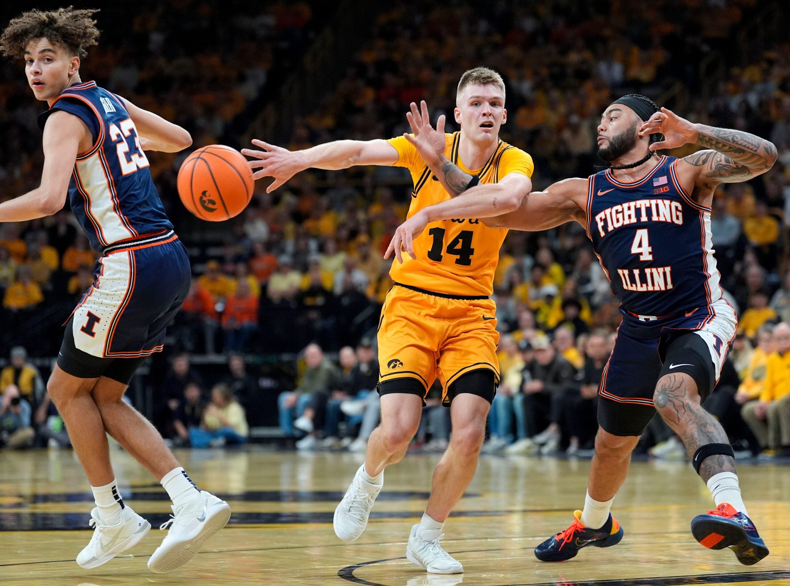 Iowa guard Bennett Stirtz (14) makes a no-look pass against Illinois guard Kylan Boswell (4) Jan. 11, 2026 at Carver-Hawkeye Arena in Iowa City, Iowa.