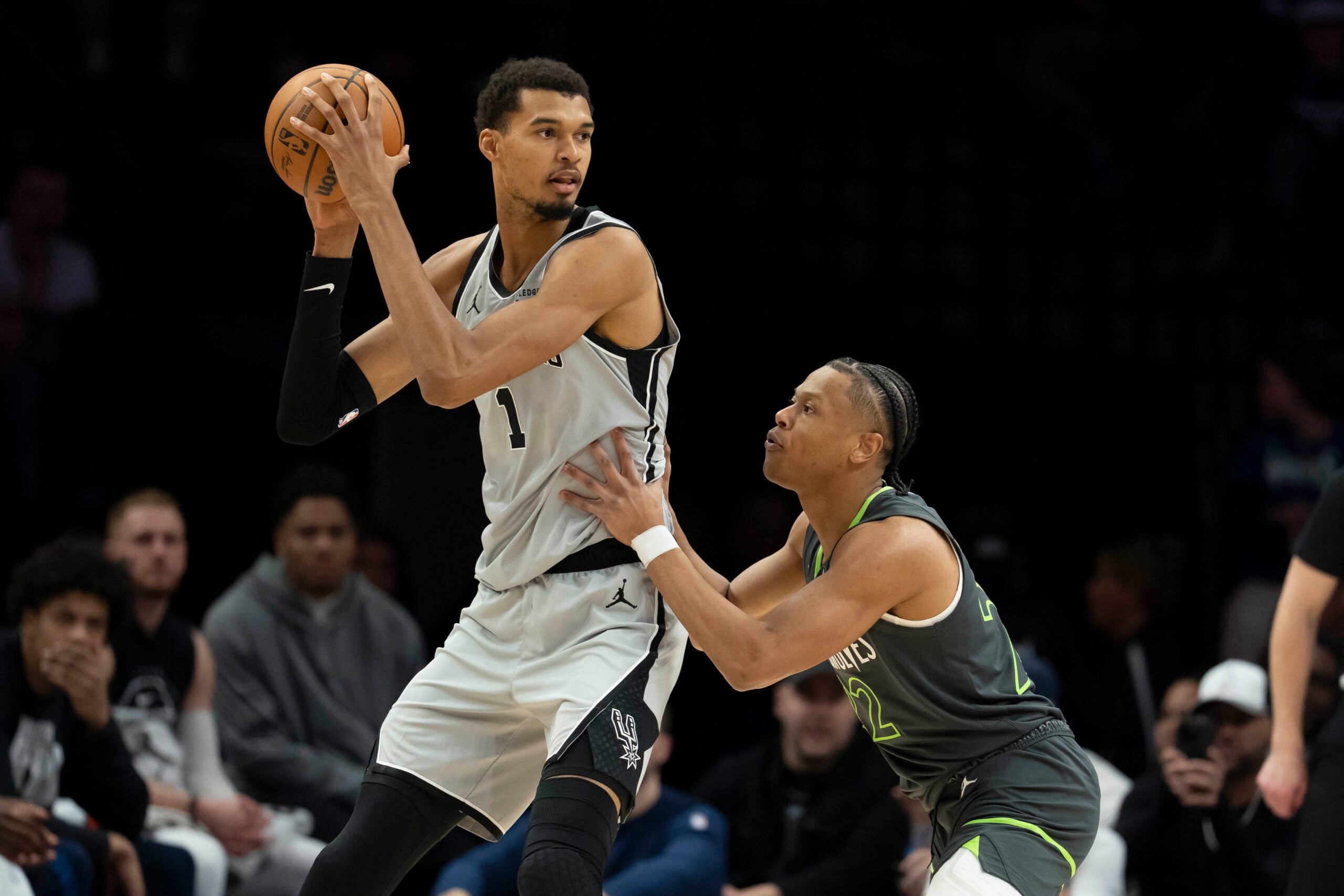 Jan 11, 2026; Minneapolis, Minnesota, USA; San Antonio Spurs forward Victor Wembanyama (1) holds the ball as Minnesota Timberwolves guard Jaylen Clark (22) plays defense in the second half at Target Center. Mandatory Credit: Jesse Johnson-Imagn Images