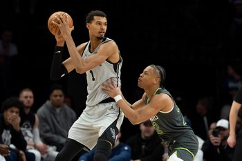 Jan 11, 2026; Minneapolis, Minnesota, USA; San Antonio Spurs forward Victor Wembanyama (1) holds the ball as Minnesota Timberwolves guard Jaylen Clark (22) plays defense in the second half at Target Center. Mandatory Credit: Jesse Johnson-Imagn Images