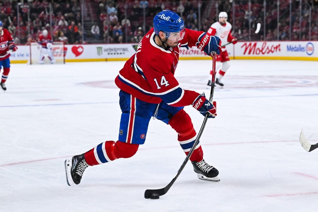 Jan 10, 2026; Montreal, Quebec, CAN; Montreal Canadiens center Nick Suzuki (14) shoots the puck against the Detroit Red Wings during the third period at Bell Centre. Mandatory Credit: David Kirouac-Imagn Images