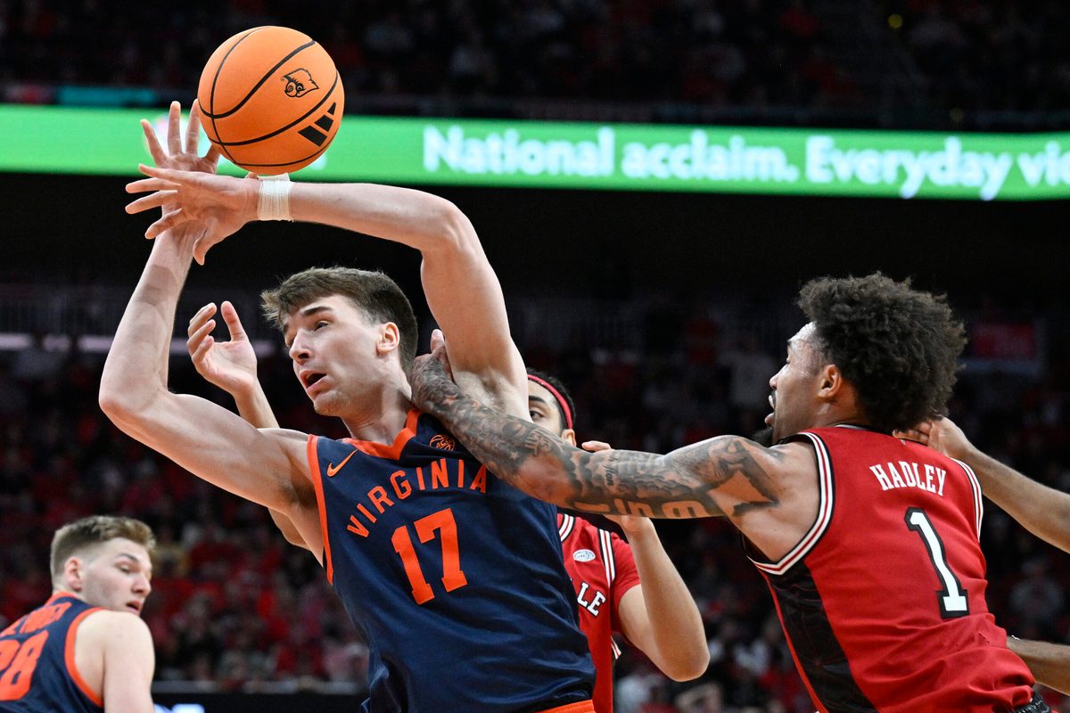 Jan 13, 2026; Louisville, Kentucky, USA; Virginia Cavaliers center Johann Gruenloh (17) draws a foul from Louisville Cardinals guard J'vonne Hadley (1) as they battle for a rebound during the second half at KFC Yum! Center. Virginia defeated Louisville 79-70. Mandatory Credit: Jamie Rhodes-Imagn Images