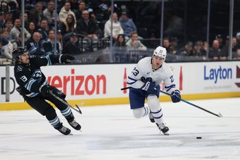 Jan 13, 2026; Salt Lake City, Utah, USA; Toronto Maple Leafs left wing Matthew Knies (23) skates with the puck against Utah Mammoth left wing Brandon Tanev (13) during the first period at Delta Center. Mandatory Credit: Rob Gray-Imagn Images