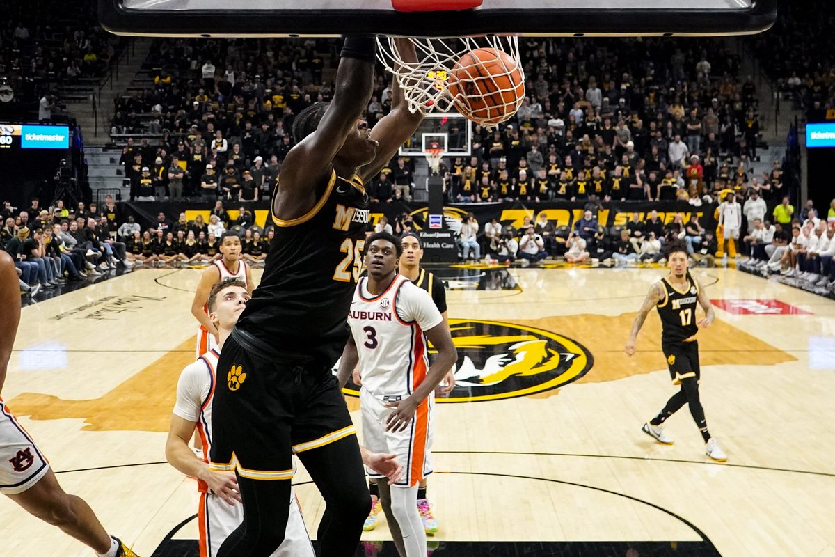 Jan 14, 2026; Columbia, Missouri, USA; Missouri Tigers guard Mark Mitchell (25) dunks he ball as Auburn Tigers forward Keshawn Murphy (3) looks on during the second half of the game at Mizzou Arena. Mandatory Credit: Denny Medley-Imagn Images