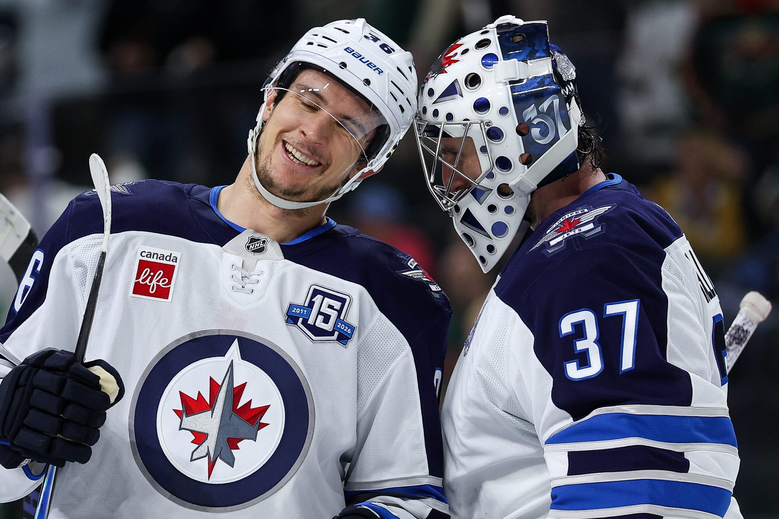 Jan 15, 2026; Saint Paul, Minnesota, USA; Winnipeg Jets center Morgan Barron (36) and goaltender Connor Hellebuyck (37) celebrate their teams win against the Minnesota Wild during the third period at Grand Casino Arena. Mandatory Credit: Matt Krohn-Imagn Images
