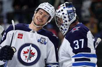 Jan 15, 2026; Saint Paul, Minnesota, USA; Winnipeg Jets center Morgan Barron (36) and goaltender Connor Hellebuyck (37) celebrate their teams win against the Minnesota Wild during the third period at Grand Casino Arena. Mandatory Credit: Matt Krohn-Imagn Images