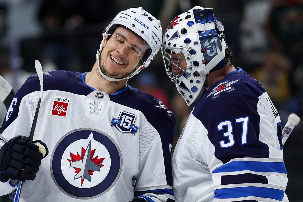 Jan 15, 2026; Saint Paul, Minnesota, USA; Winnipeg Jets center Morgan Barron (36) and goaltender Connor Hellebuyck (37) celebrate their teams win against the Minnesota Wild during the third period at Grand Casino Arena. Mandatory Credit: Matt Krohn-Imagn Images