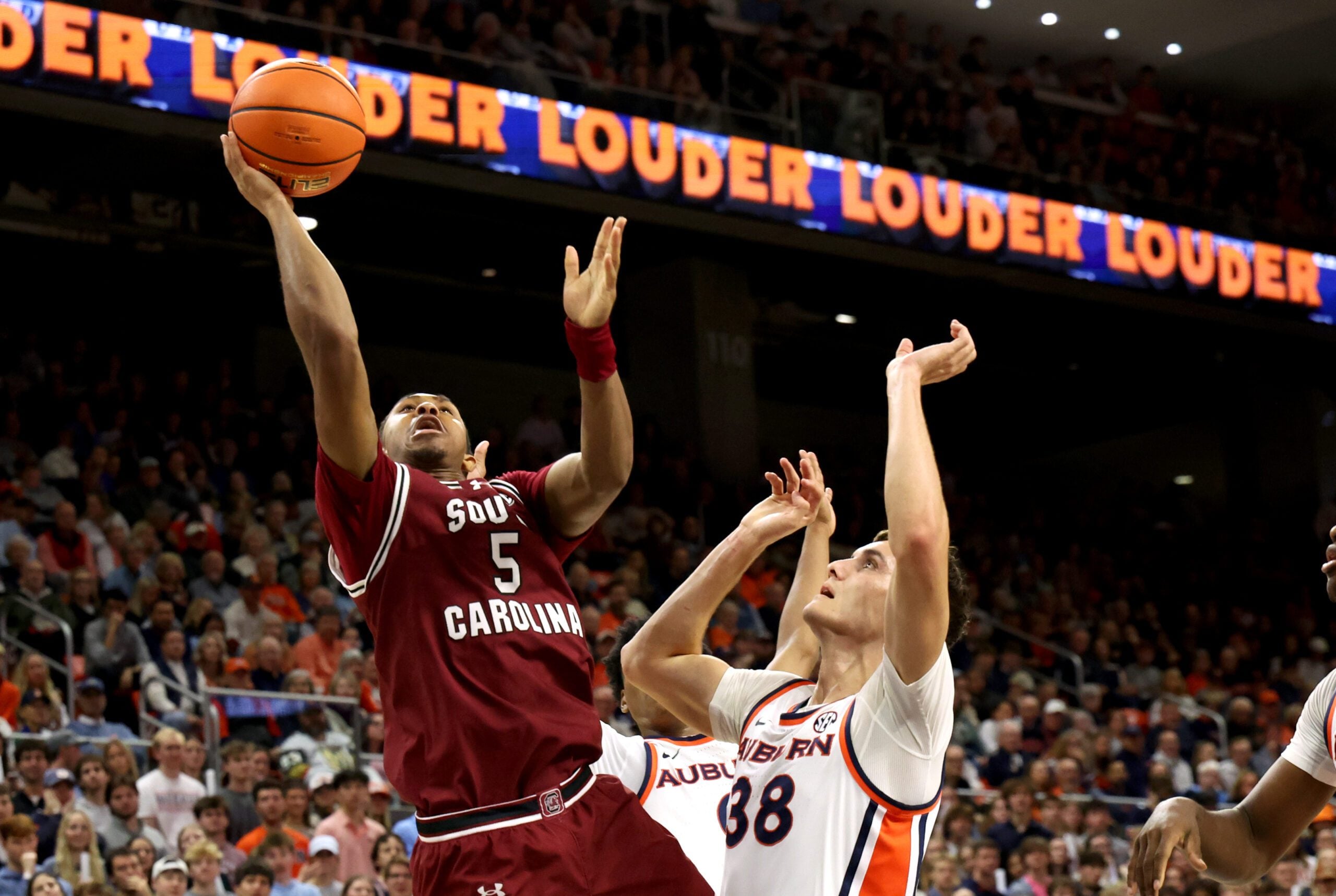 Jan 17, 2026; Auburn, Alabama, USA; South Carolina Gamecocks guard Meechie Johnson (5) gets past Auburn Tigers forward Filip Jovic (38) for a shot during the first half at Neville Arena. Mandatory Credit: John Reed-Imagn Images