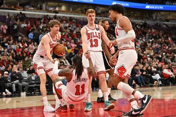Jan 18, 2026; Chicago, Illinois, USA; Chicago Bulls forward Matas Buzelis (14) and guard Kevin Huerter (13) help up guard Ayo Dosunmu (11) against the Brooklyn Nets during the second half at United Center. Mandatory Credit: Patrick Gorski-Imagn Images