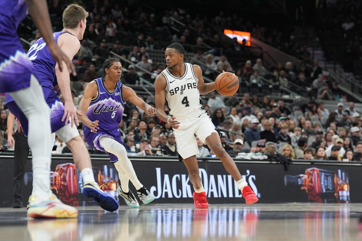 Jan 19, 2026; San Antonio, Texas, USA; San Antonio Spurs guard De'aaron Fox (4) dribbles the ball against Utah Jazz forward Cody Williams (5) during the second half at Frost Bank Center. Mandatory Credit: Daniel Dunn-Imagn Images