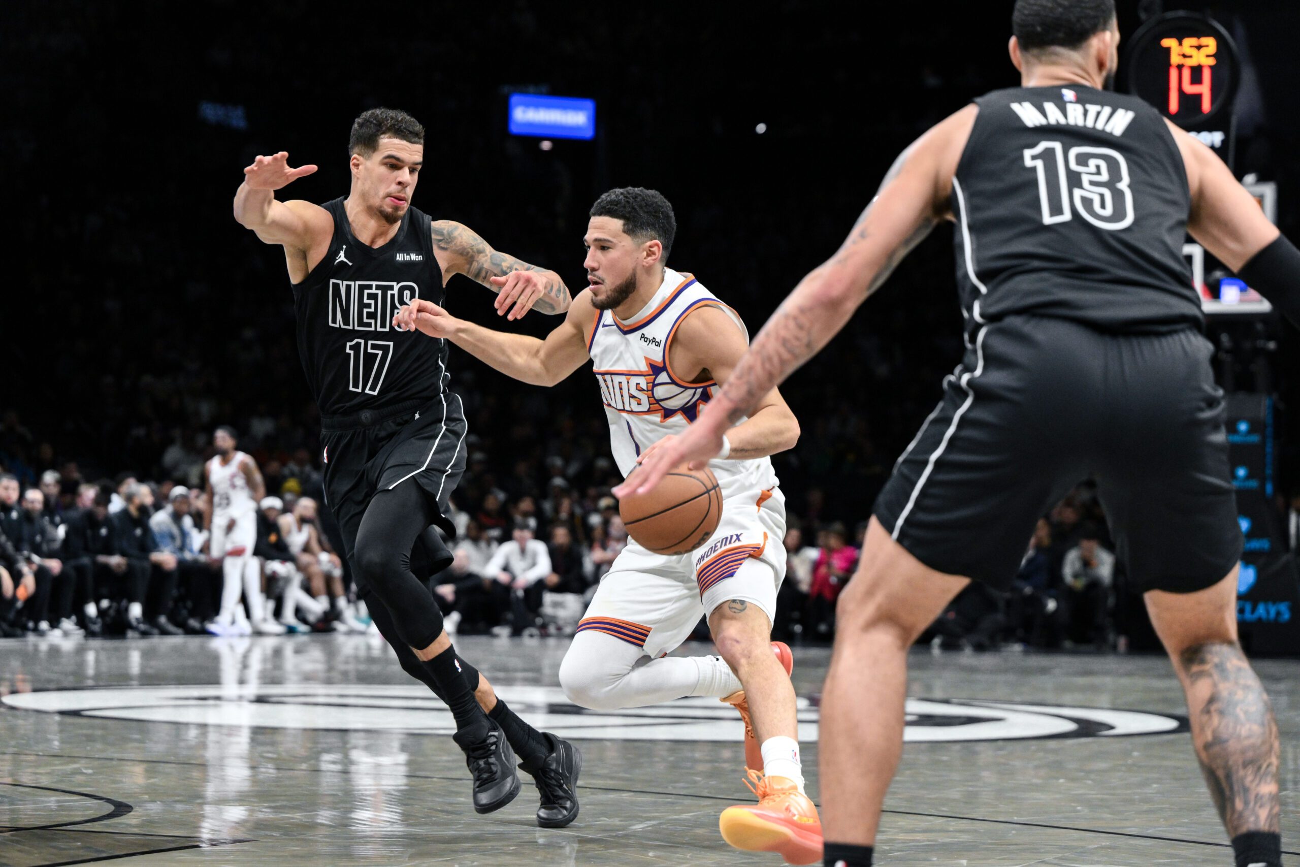 Jan 19, 2026; Brooklyn, New York, USA; Phoenix Suns guard Devin Booker (1) drives against Brooklyn Nets forward Michael Porter Jr. (17) during the second half at Barclays Center. Mandatory Credit: John Jones-Imagn Images