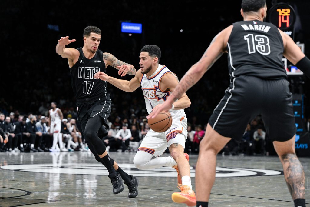 Jan 19, 2026; Brooklyn, New York, USA; Phoenix Suns guard Devin Booker (1) drives against Brooklyn Nets forward Michael Porter Jr. (17) during the second half at Barclays Center. Mandatory Credit: John Jones-Imagn Images