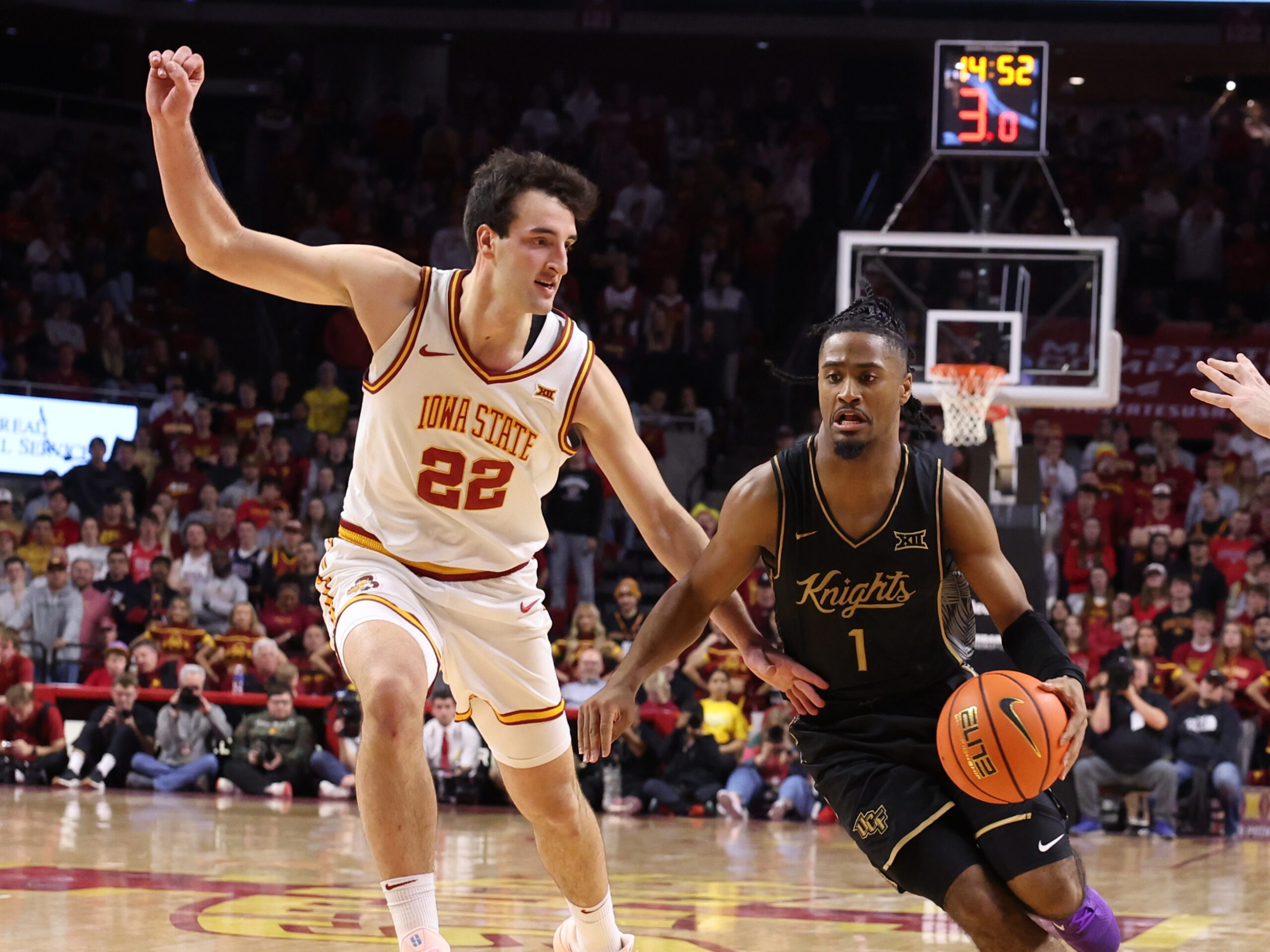 Jan 20, 2026; Ames, Iowa, USA; UCF Knights guard Themus Fulks (1) is defended by Iowa State Cyclones forward Milan Momcilovic (22) during the first half at James H. Hilton Coliseum. Mandatory Credit: Reese Strickland-Imagn Images